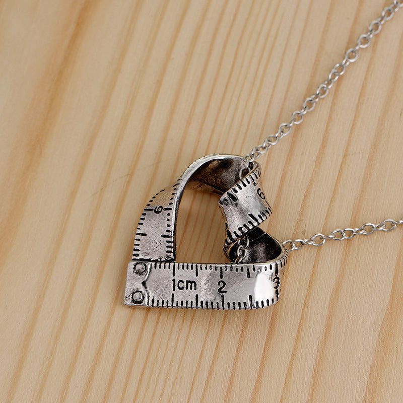 Heart-shaped rotating tape measure necklace